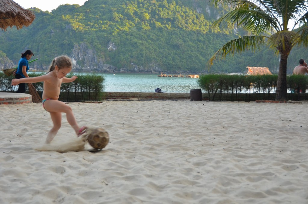 menina jogando bola halong bay areia futebol criança