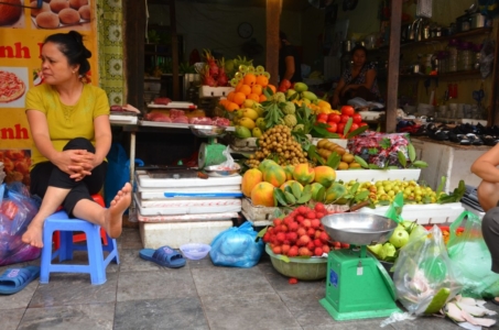 frutas vietnam hanoi mercado de rua vendedora pé para o alto rambutam